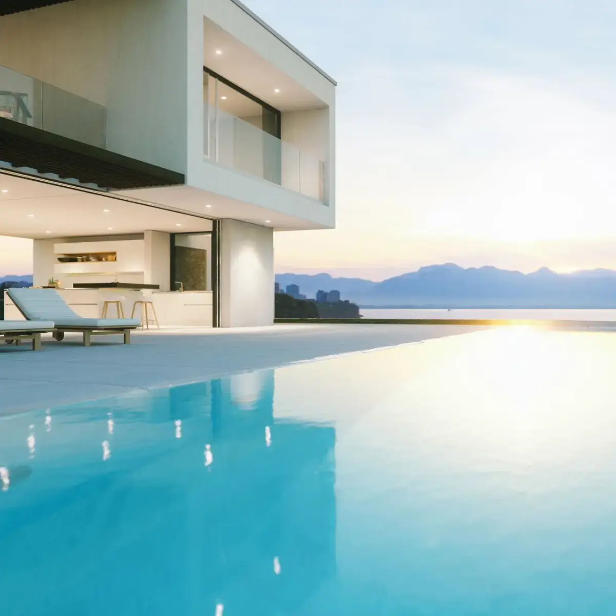 Modern luxury house with infinity pool overlooking the ocean at sunset