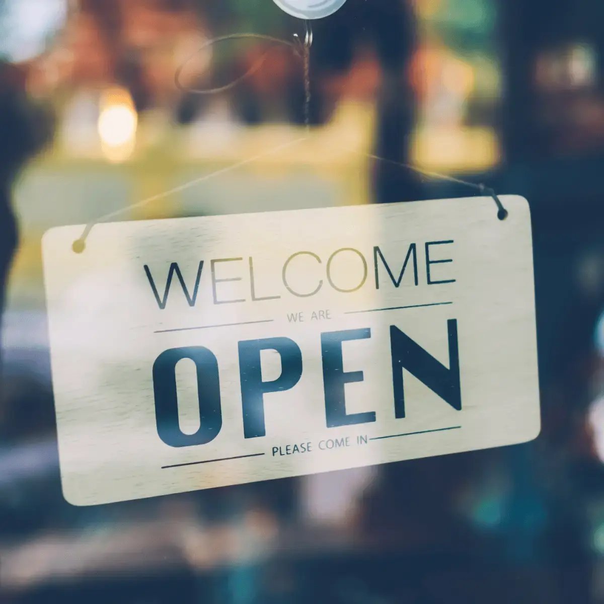 Open sign displayed on shop door welcoming customers